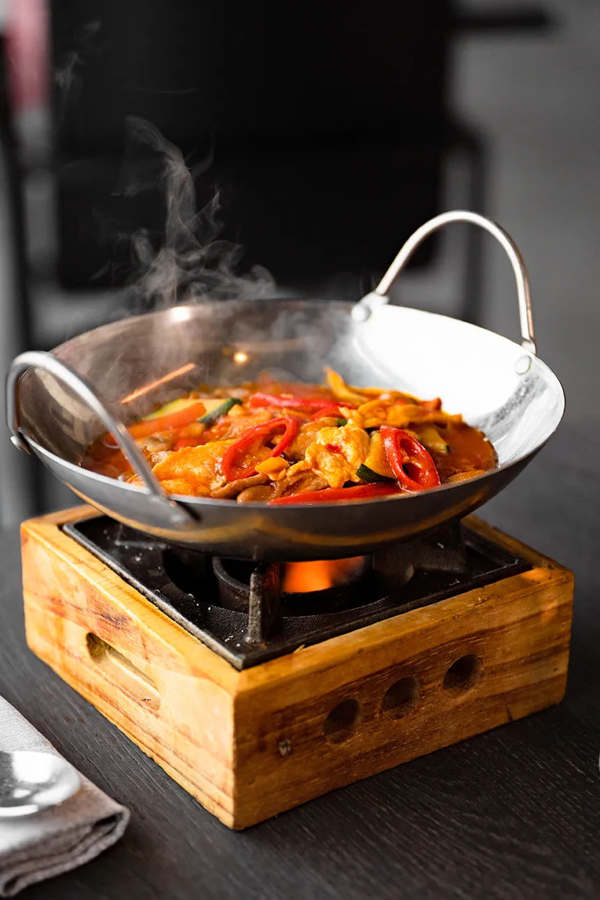Wok di carne piccante con verdure, servito fumante