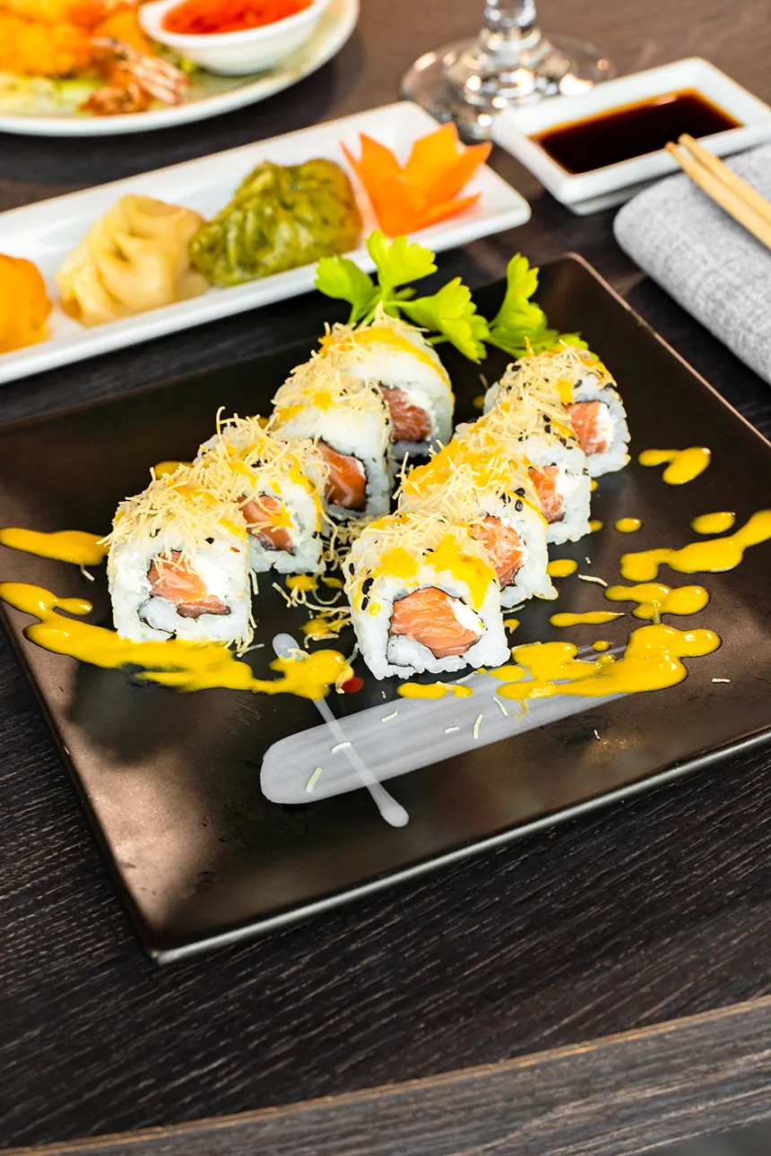 Uramaki con salmone, formaggio e granella dorata